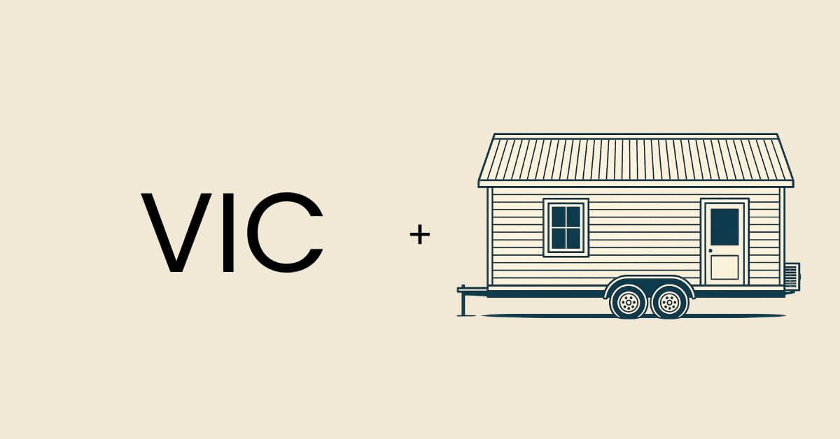 The term VIC positioned next to a tiny home on wheels.